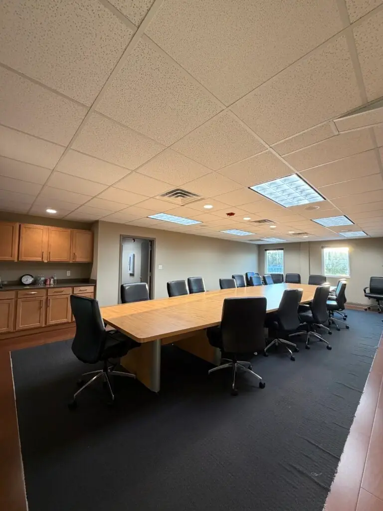 Boardroom Suites boardroom in Metairie with 22-seat meeting table and refreshment cabinetry and sink