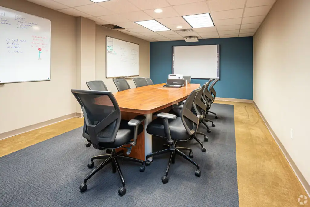 Boardroom Suites conference room in Metairie with 10-seat table, whiteboards and presentation screen