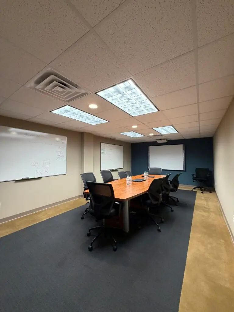Boardroom Suites conference room in Metairie with 10-seat table, whiteboards and presentation screen