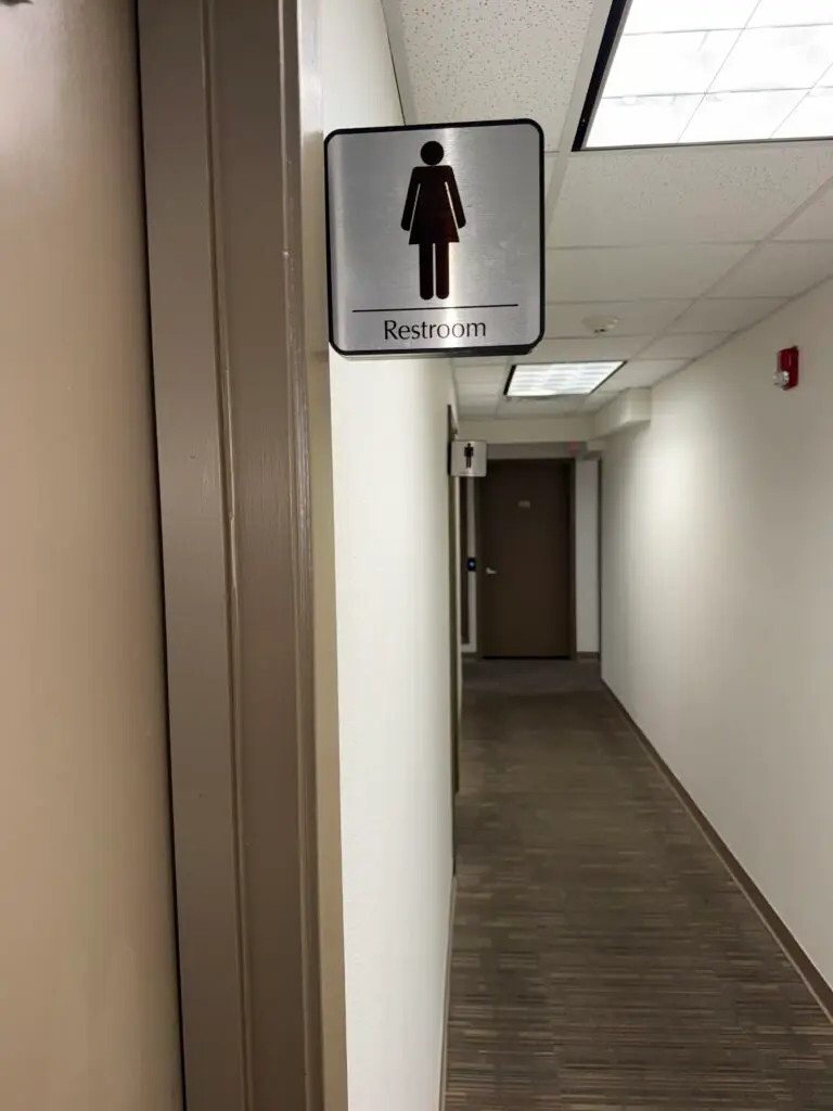 Boardroom Suites women&rsquo;s restroom hallway in Metairie with directional restroom signage