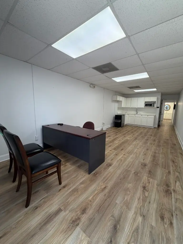 Suite 102 first-floor office in Metairie showing furnished workspace, guest seating and private kitchenette