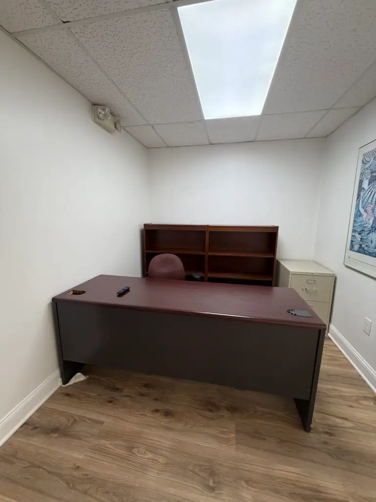 Suite 102 furnished private office in Metairie with desk, shelving and file storage