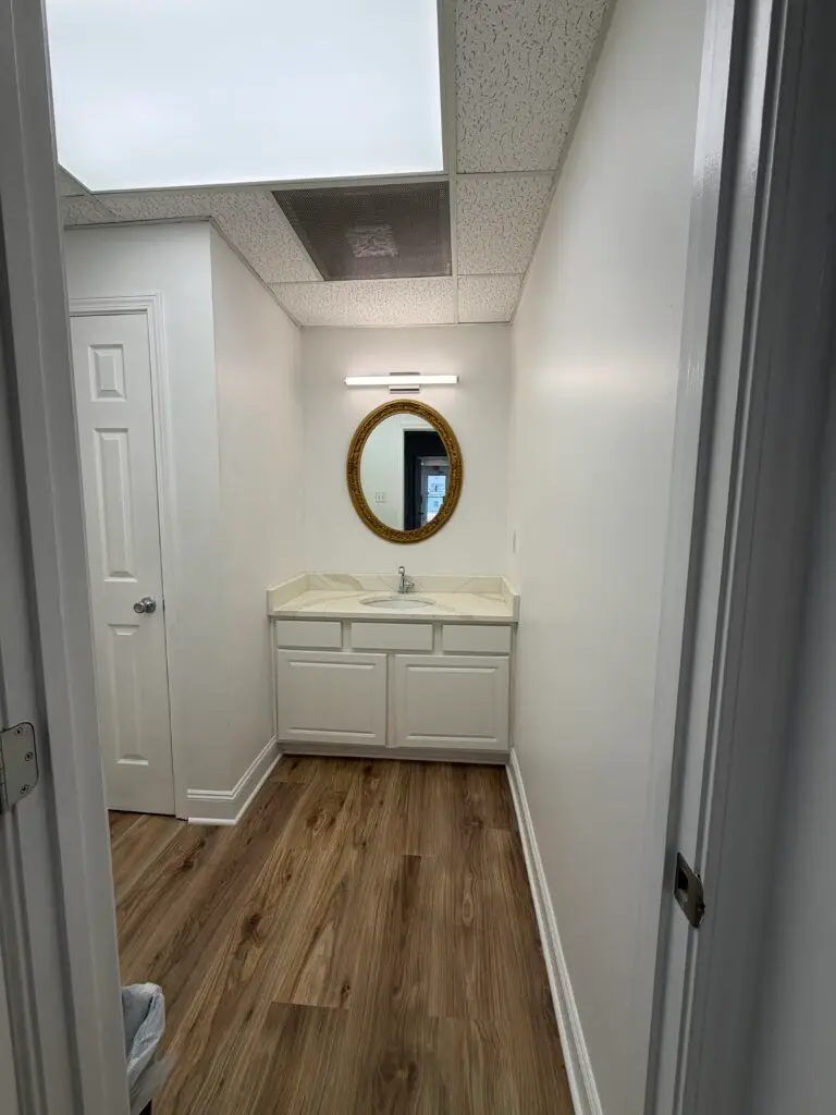 Suite 102 private restroom area in Metairie with vanity, sink and storage