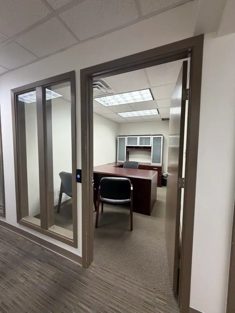 Boardroom Suites Suite 205 private office in Metairie viewed from the hallway entrance with executive desk and guest seating