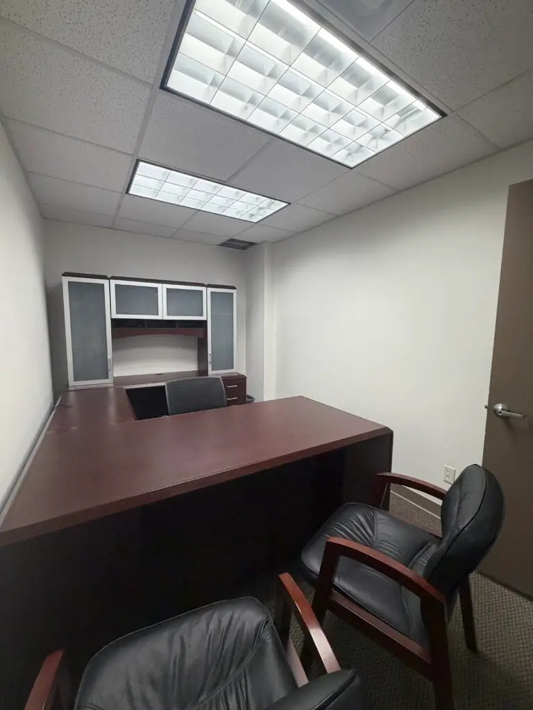 Boardroom Suites Suite 205 furnished private office in Metairie with executive desk, guest chairs and storage hutch