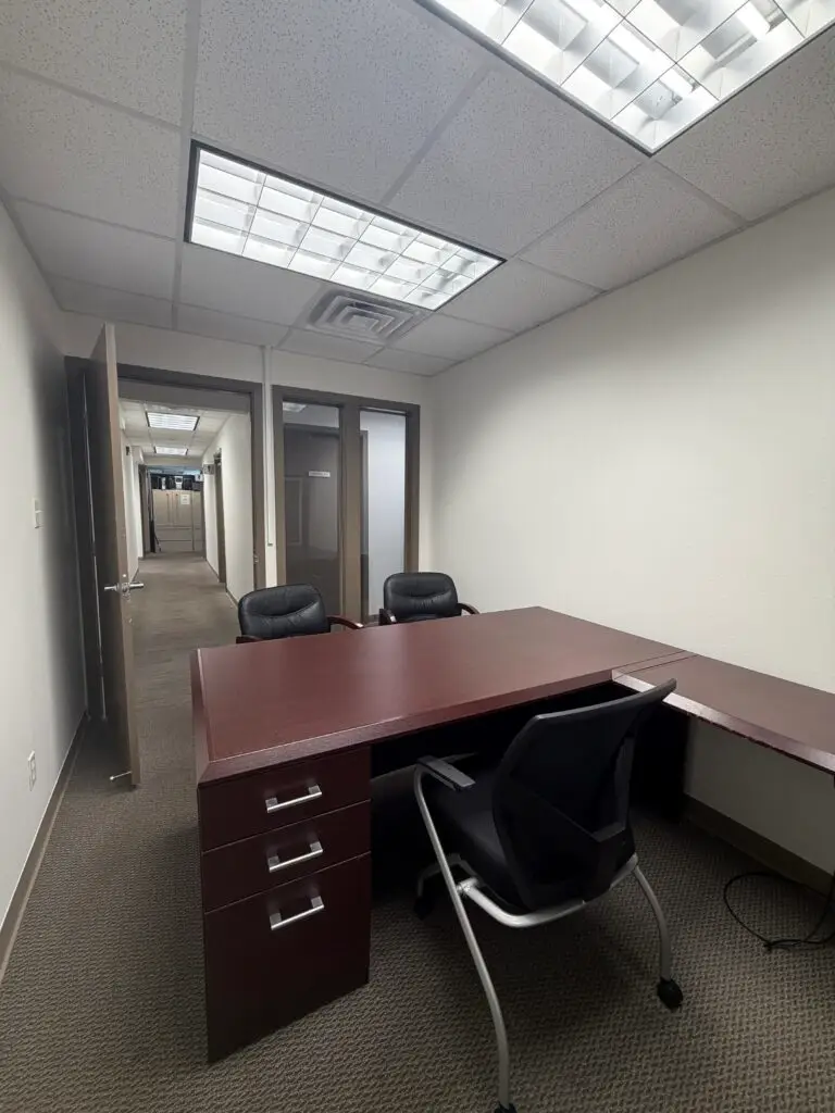 Boardroom Suites Suite 205 private office in Metairie showing desk workspace, guest seating and hallway access
