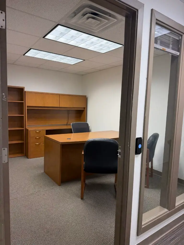 Boardroom Suites Suite 206 private office in Metairie viewed from the hallway entrance with desk, guest seating and built-in storage
