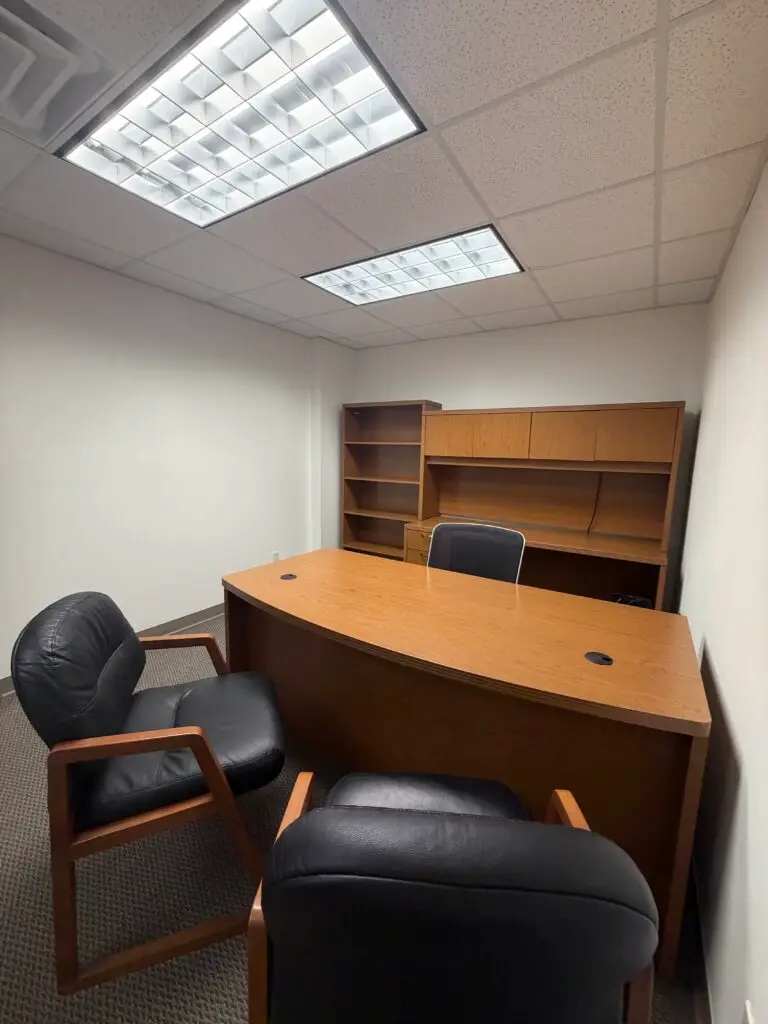 Boardroom Suites Suite 206 furnished private office in Metairie with executive desk, guest chairs and storage hutch