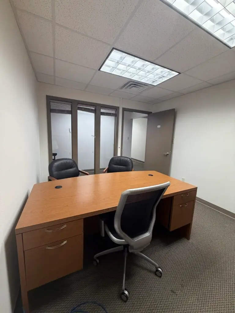 Boardroom Suites Suite 206 private office in Metairie showing desk workspace, guest seating and interior windows