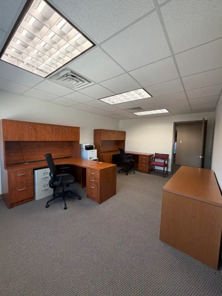Boardroom Suites Suite 224 furnished private office in Metairie showing two desks, storage cabinetry and open floor space